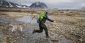 Guide with dog, jumping over a riverbed