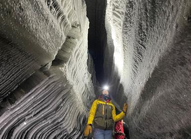 A person admiring the formations in the ice cave