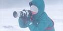 En fotograf som tar bilder i snøstorm.