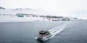 MS Bard som seiler på sjøen med Barentsburg i bakgrunnen