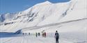 Participants at Svalbard Skimaraton in the ski tracks with mountains in the background