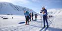 Participants at Svalbard Skimaraton skiing past specators along the track