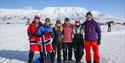 Spectators at Svalbard Skimaraton posing for a photo with the Norwegian flag