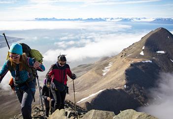 Persons hiking above the clouds on the top of hiortfjellet