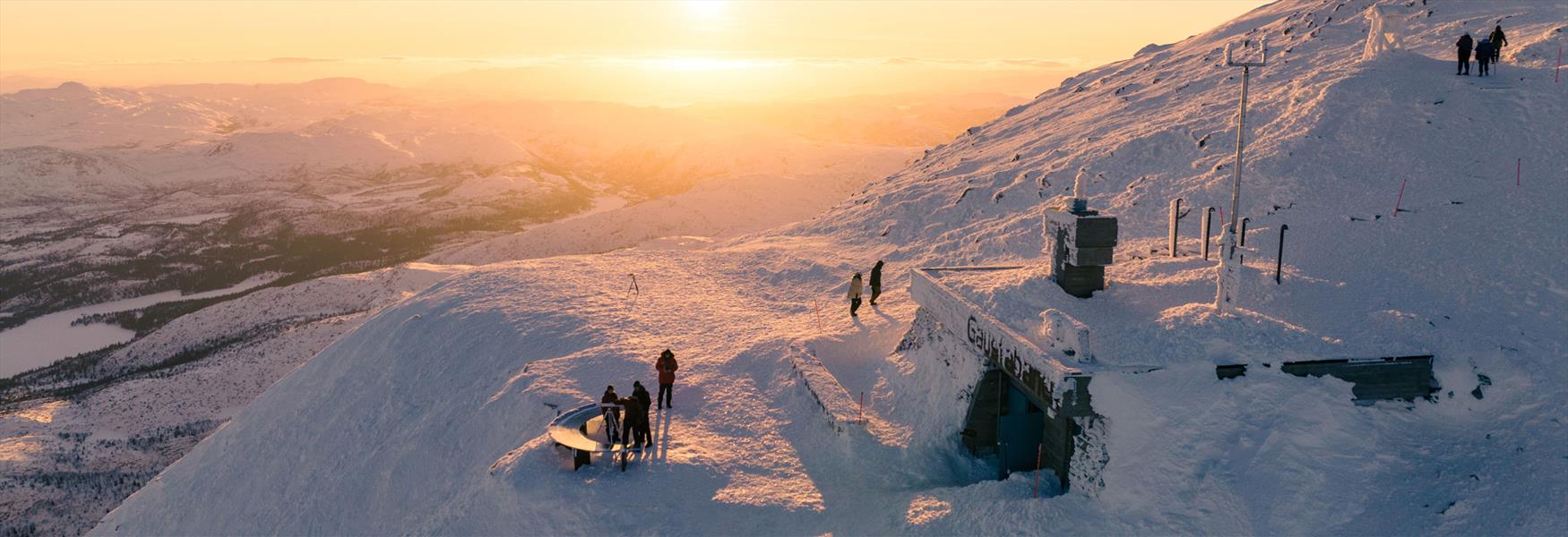 people on top of Gaustatoppen in the evening