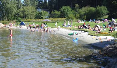 folk som bader på sandstrand på Dikkon badeplass på Sandøya