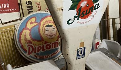 Bilde av et gammelt diplomis-skile og en gammel vekt