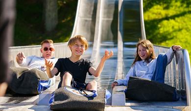 children sliding down a slide at Foldvik family park