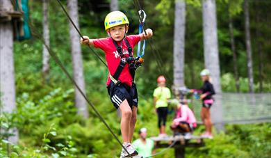 barn som klatrer i klatreparken Høyt og Lavt i Bø i Telemark