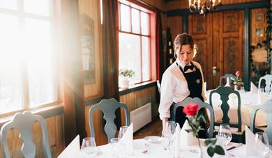 servitrise dekker bord på restaurant på Tuddal Høyfjellshotell