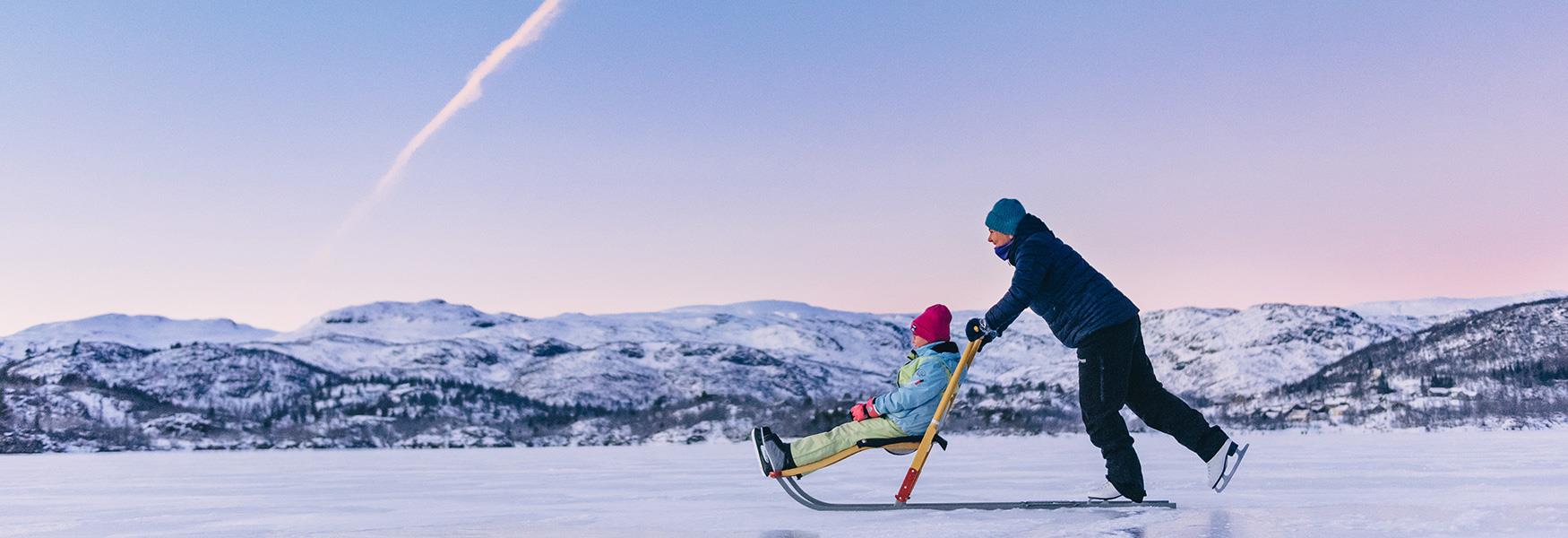 father and daughter ice skating on the frozen lake at Haukeli