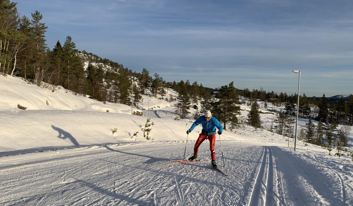 En mann på ski oppover en bakke
