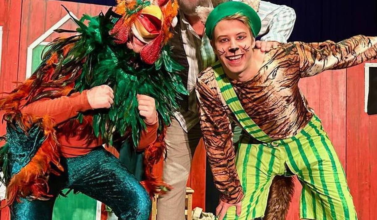 mann med gul hatt, skjegg og briller, ung gutt med grønn lue og stripete dress med grønn stripete buske