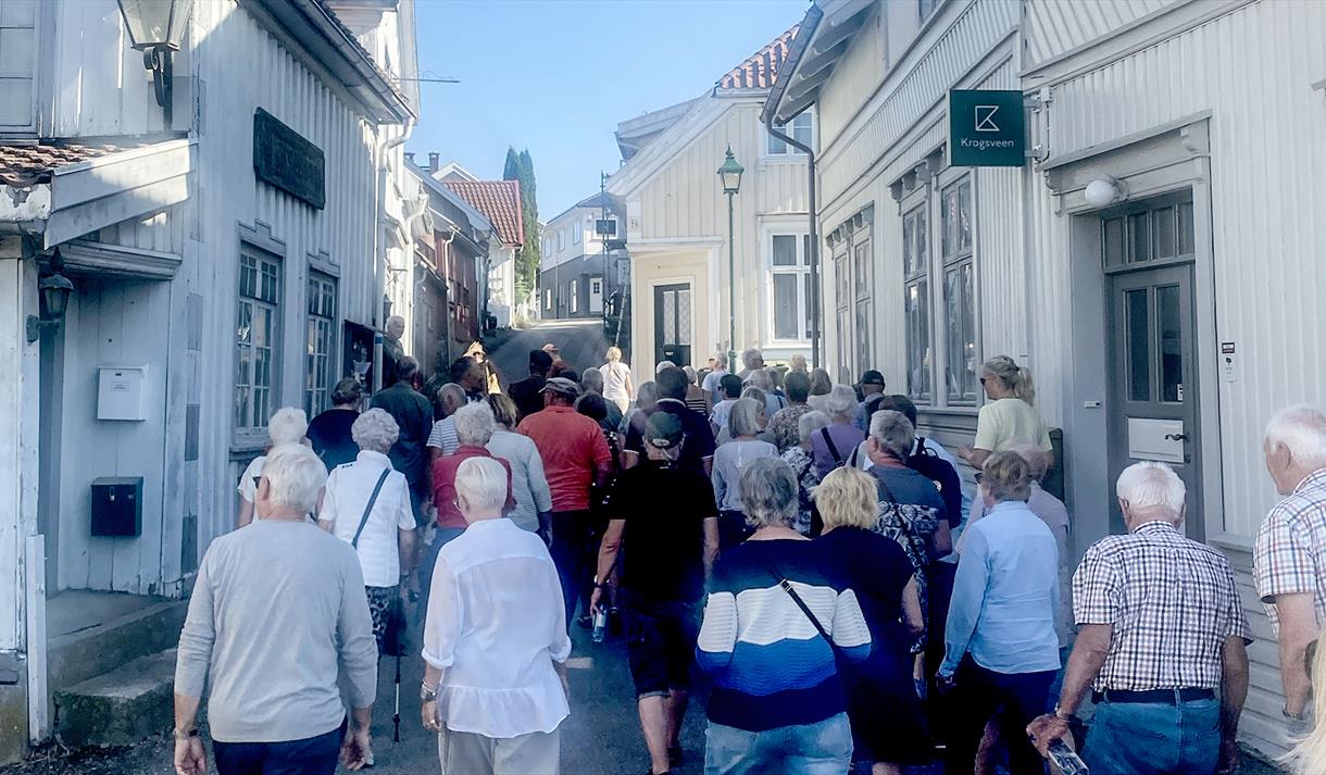 folkemenge på vandring blant gamle hus