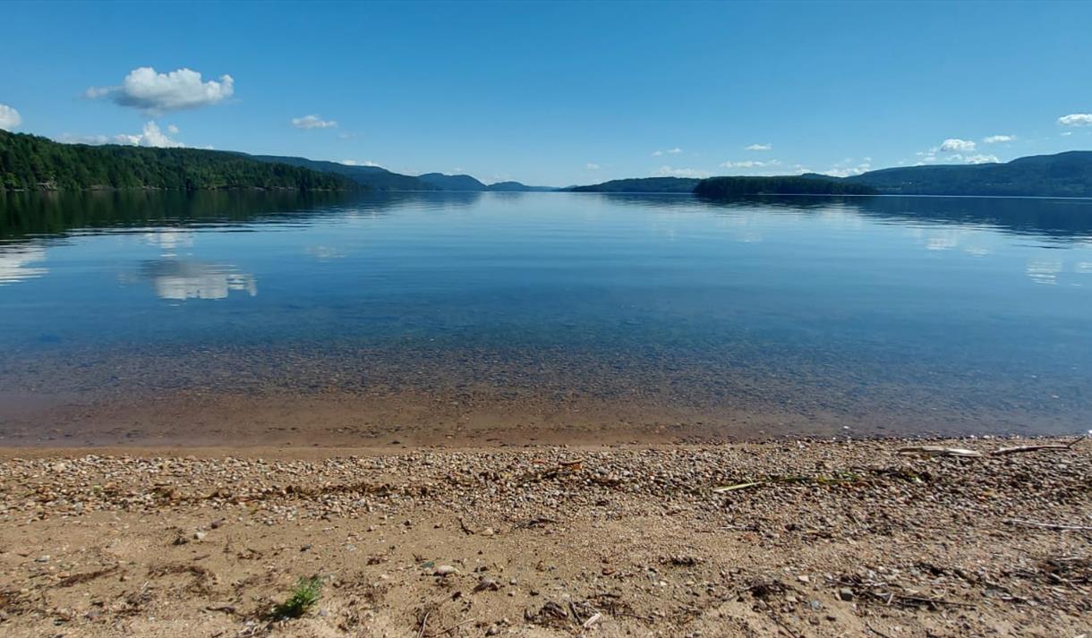 strand ved en rolig innsjø