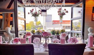 nicely set table in front of an open balcony door at Gamle Skien Restaurant