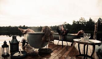 man and woman enjoying themselves in the zinc baths at the wilderness spa at Canvas Hotel