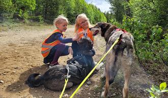 2 girls pet the dogs from Telemark Husky Tours