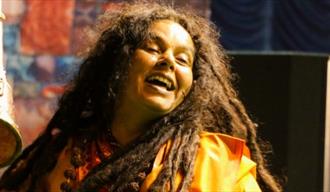 PARVATHY BAUL med rastafletter og gul jakke