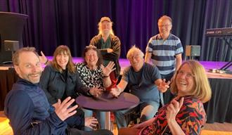 gruppe mennesker som sitter rundt et bord
