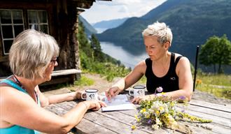 2 damer som sitter ved et bord ved Rui-plassen og ser på kart