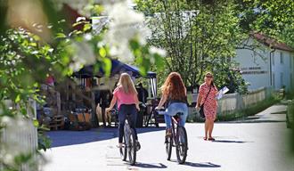 2 jenter som sykler langs en gate i Fyresdal