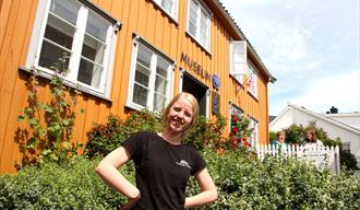 employee from Telemark museum stands in front of Kittelsenhuset in Kragerø