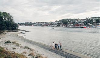 familie som går langs vannet på Langøya badeplass