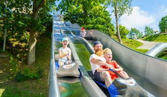 barn og voksen på rutsje i Foldvik familiepark