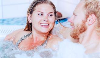 mann og dame slapper av i boblebad på Spa og velværeavdeling i Skien fritidspark