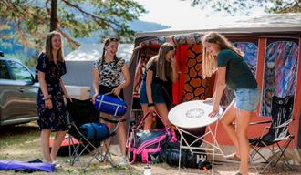 girls unpack tents and equipment at Telnessanden camping