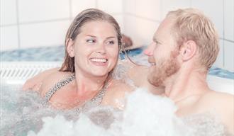 man and woman relax in a jacuzzi at the Spa and wellness department in Skien leisure park