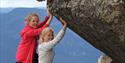 2 girls "hold" a large stone