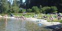 people swimming on a sandy beach at Dikkon bathing place on Sandøya