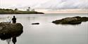 2 sitting on a rock on Furustranda and looking towards Langøytangen lighthouse