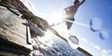 boy jumps into the water from a jetty