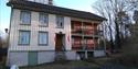 hvitt trehus med grønne og røde detaljer