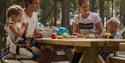 family sitting and eating at the climbing park Høyt og Lavt in Bø in Telemark