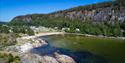 badestrand med sand, svaberg og campingvogner