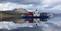 The Fjone ferry with 2 cars and several people on board operates over Lake Nisser in Telemark