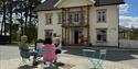 3 ladies sit in front of the shop "Oleas Hus" in Fyresdal