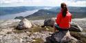 jente sitter på toppen av Hægefjell og nyter utsikten