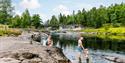 A family with children swimming at Omnesfossen waterfall.