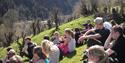 group of young people sitting outside listening to a lecture