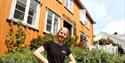 employee from Telemark museum stands in front of Kittelsenhuset in Kragerø