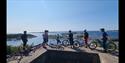 group of cyclists stands and looks out over the Kragerø archipelago