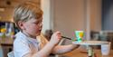 boy painting a cup at the porcelain museum in Porsgrunn