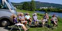 bobilcamper sitter forran bobilen på Notodden Bobilcamp. Foto