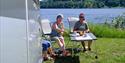 couple sitting in front of the motorhome at Notodden Motorhome Camp