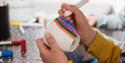 child paints on a cup at the Porcelain Museum in Porsgrunn